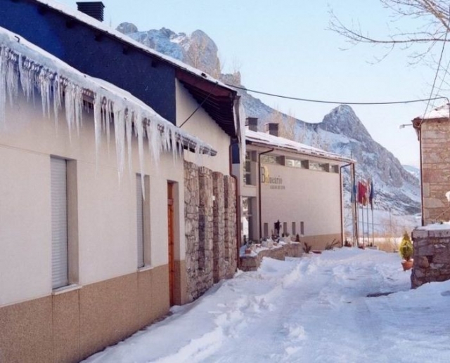Casa con hielo en el techo y nieve en el suelo